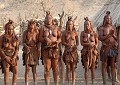 A quelques kilomètres d'Opuwo, capitale du Kaokoland, dont le nom signifie "la fin", rencontre avec les Himbas, dans un village qui regroupe une cinquantaine de personnes. Les Himbas, au nombre de 10 000 individus se répartissent entre la Namibie (2/3) et l'Angola (1/3). Ils sont rattachés à l'ethnie Herero et appartiennent au groupe linguistique Bantou. Ils vivent sur un territoire immense, sauvage, impénétrable, arrosé par la rivière Kunene... Sur cette vue on peut observer que les femmes vivent poitrine nue et portent des jupes traditionnelles, formées de plusieurs couches de peaux de chèvres... himbas,kaokoland,namibie,afrique. 