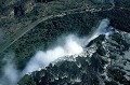 Elles font face à deux pays : la Zambie à gauche de l'image et le Zimbabwe à droite. On aperçoit la frontière sur la route et la voie du chemin de fer qui longent le site. zambeze,chutes,victoria,zimbabwe,zambie. 